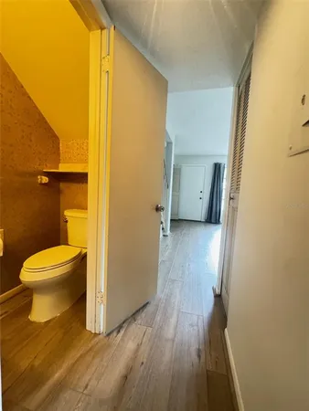 a bathroom with a toilet and a wooden floor