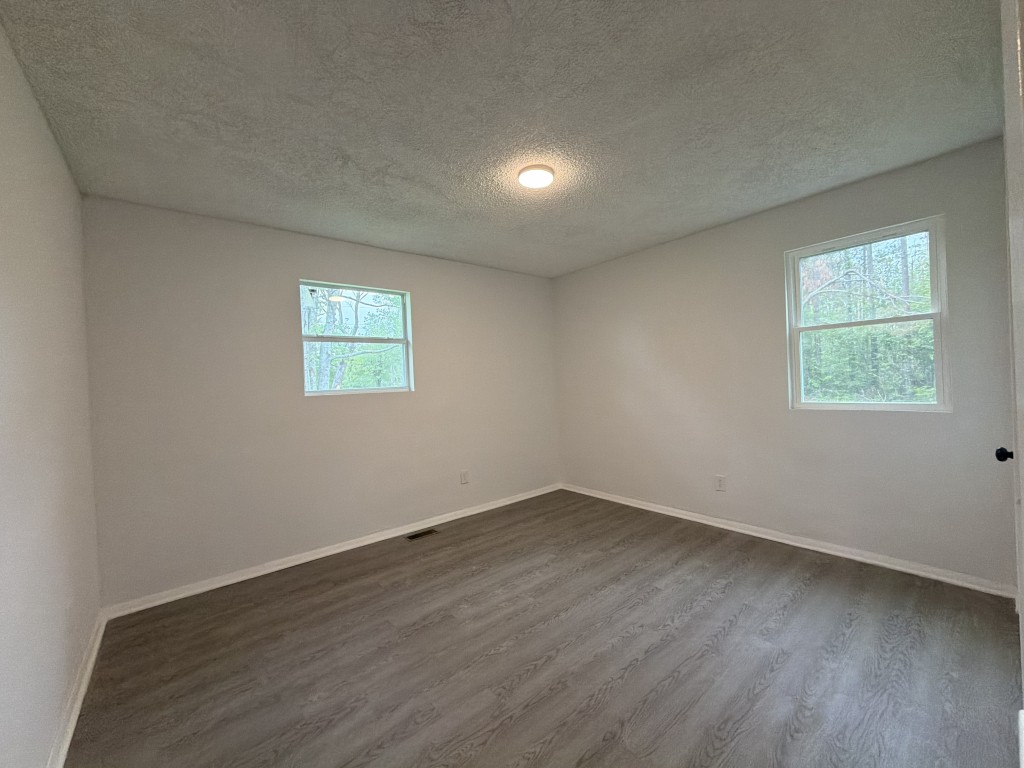 920 Damron Loop Counce, TN 38326 - Photo 10 of 14 an empty room with wooden floor and windows