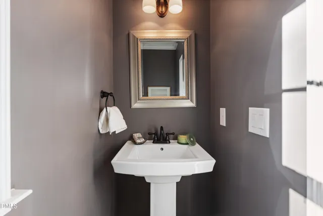 a bathroom with a sink shower and a mirror