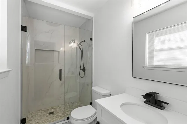 a bathroom with a toilet sink a shower and a mirror