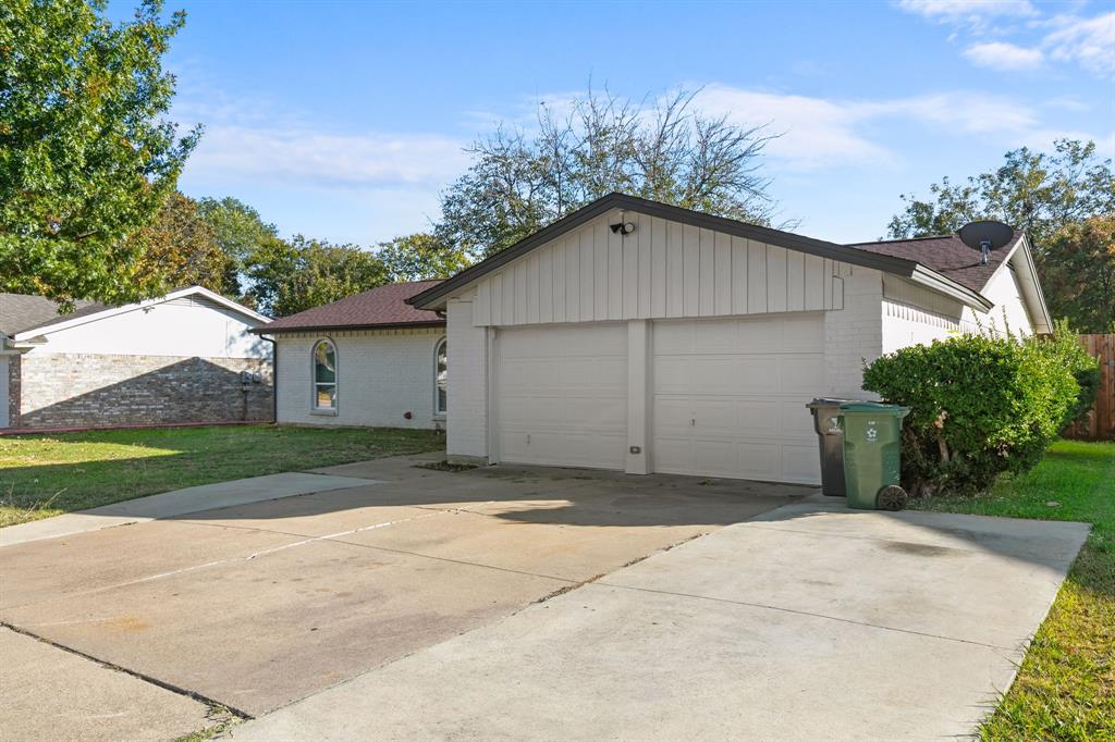 1002 Wembley Road Arlington, TX 76014 - Photo 2 of 20 a view of a house with a yard and garage
