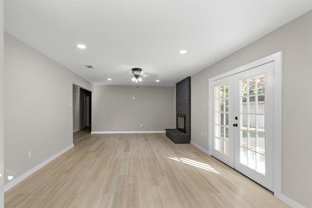 1002 Wembley Road Arlington, TX 76014 - Photo 4 of 20 an empty room with wooden floor and windows