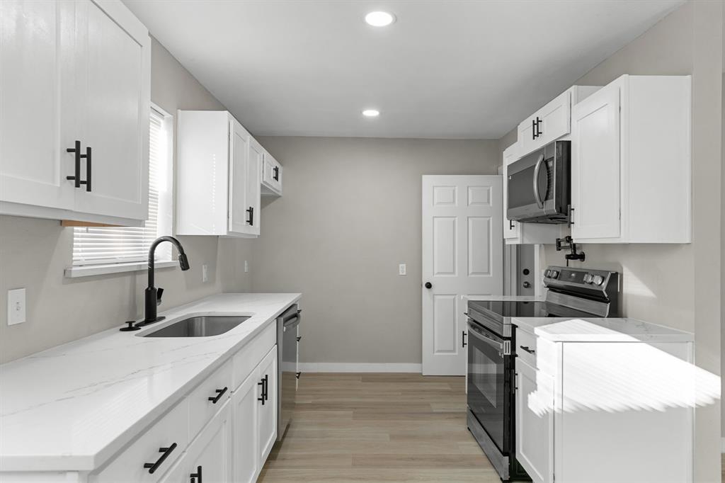 1002 Wembley Road Arlington, TX 76014 - Photo 5 of 20 a kitchen that has a sink and a stove