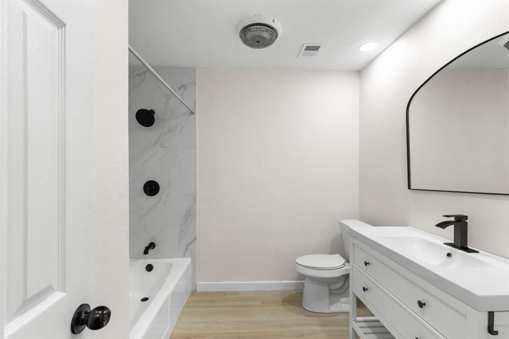 1002 Wembley Road Arlington, TX 76014 - Photo 9 of 20 a bathroom with a toilet sink a shower and mirror
