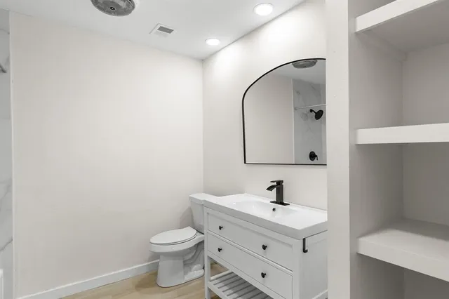 a bathroom with a sink toilet and a mirror