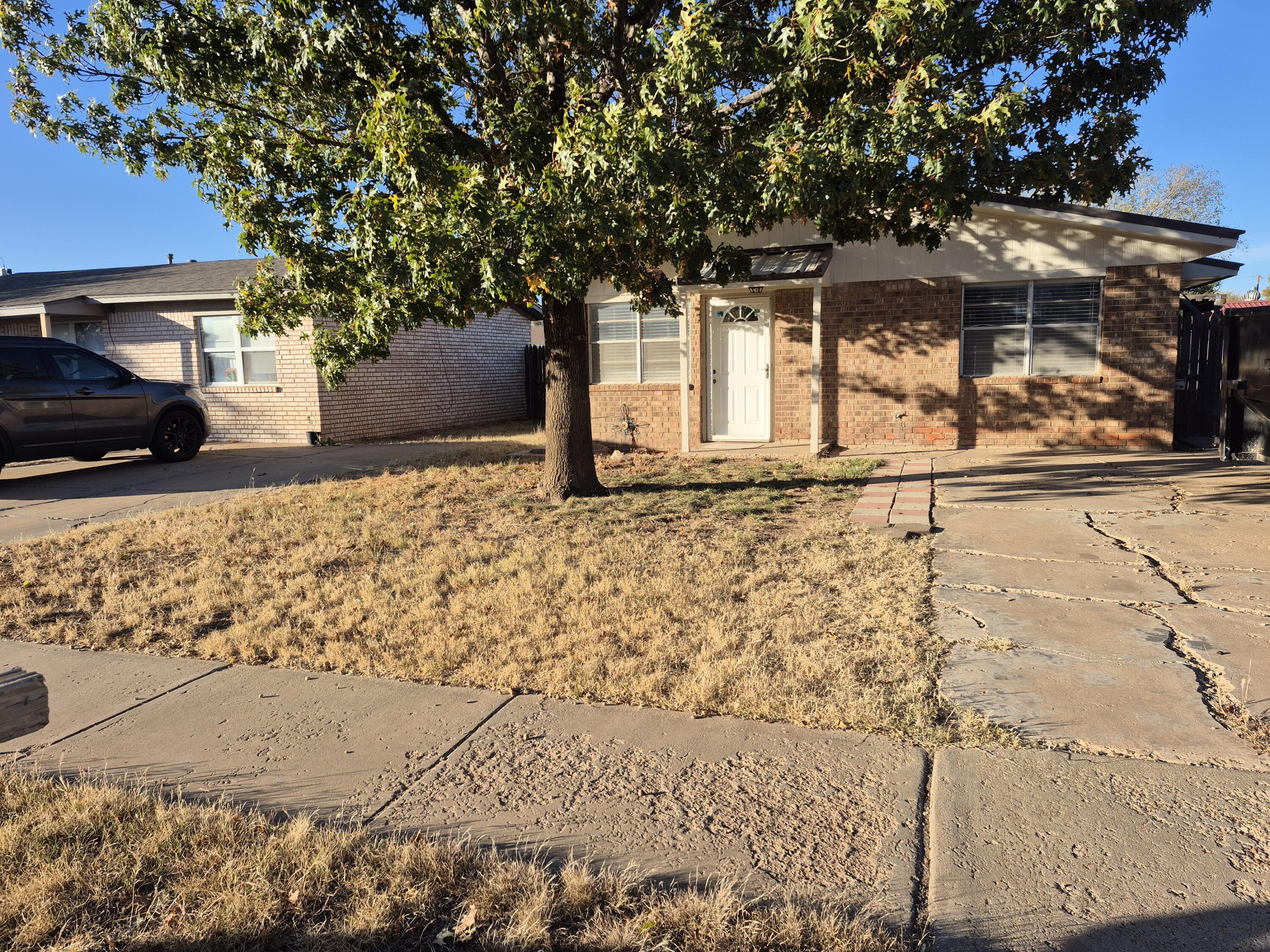 6404 28th Street Lubbock, TX 79407 - Photo 1 of 13 a front view of a house with a yard