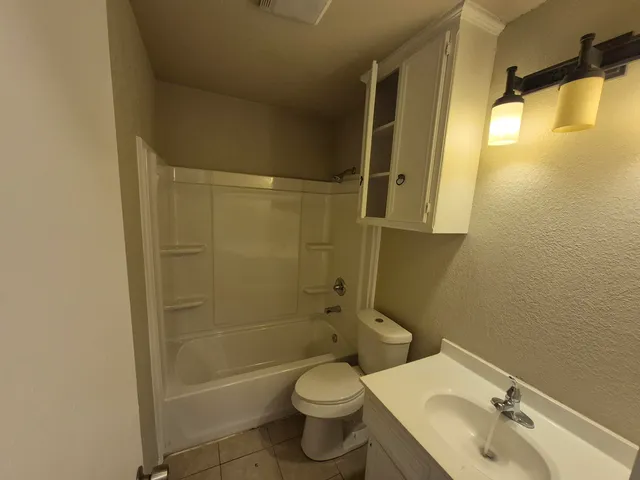 a bathroom with a granite countertop toilet sink and shower