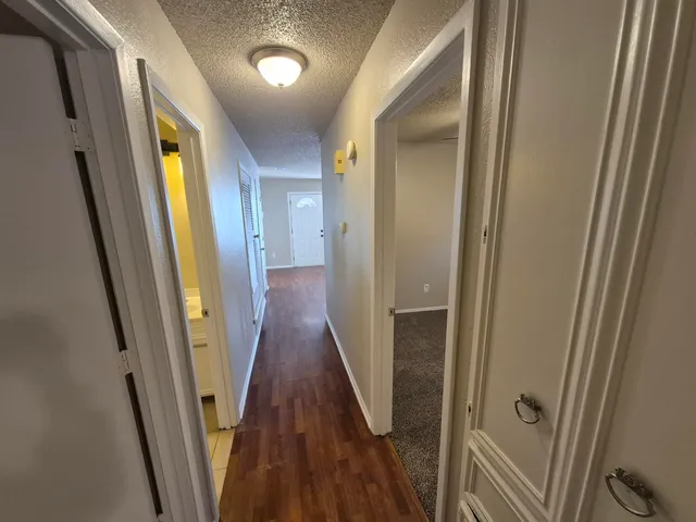 a view of a hallway with wooden floor and stairs