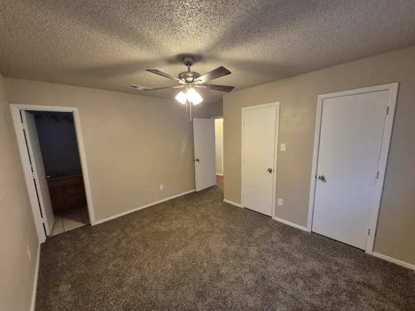 an empty room with fan and entrance