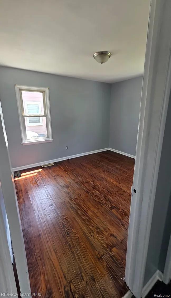 6646 Harding Street Taylor, MI 48180 - Photo 6 of 9 Room featuring wood-finish flooring, a single window with white trim, and light blue walls