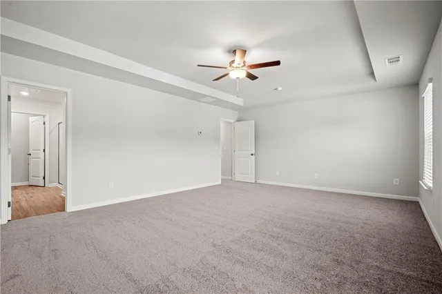 an empty room with a ceiling fan and a window