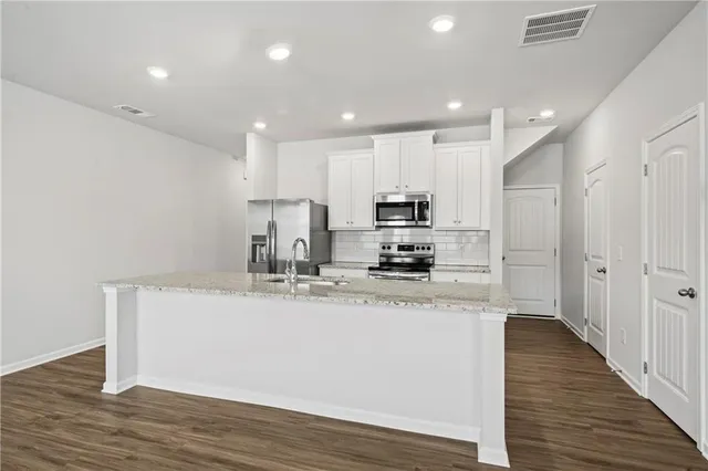 a kitchen with stainless steel appliances a refrigerator sink and microwave