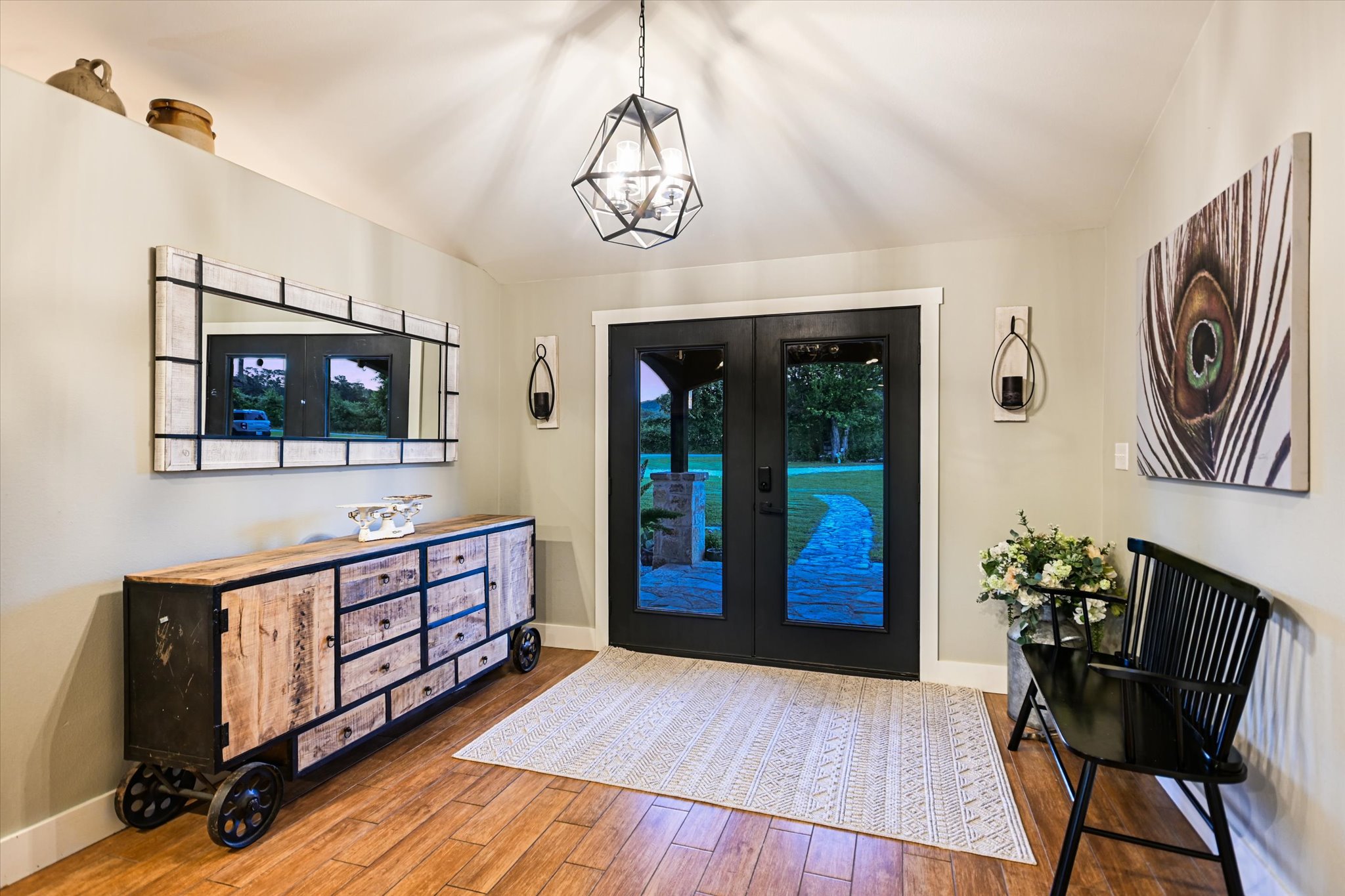 2411 Spoke Hollow Road Wimberley, TX 78676 - Photo 5 of 37 Solid wood flooring and an elegant light fixture adorn this welcoming entryway.