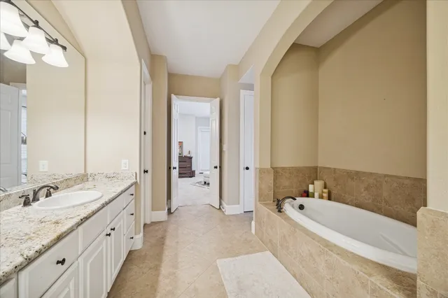 a spacious bathroom with a granite countertop tub sink and mirror