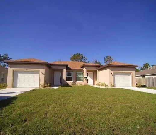 a view of a house with a big yard and large tree
