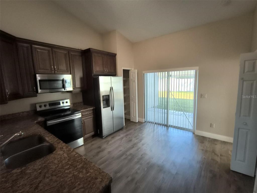 13 Wood Amber Lane, Unit B Palm Coast, FL 32164 - Photo 4 of 7 a kitchen with a refrigerator an oven