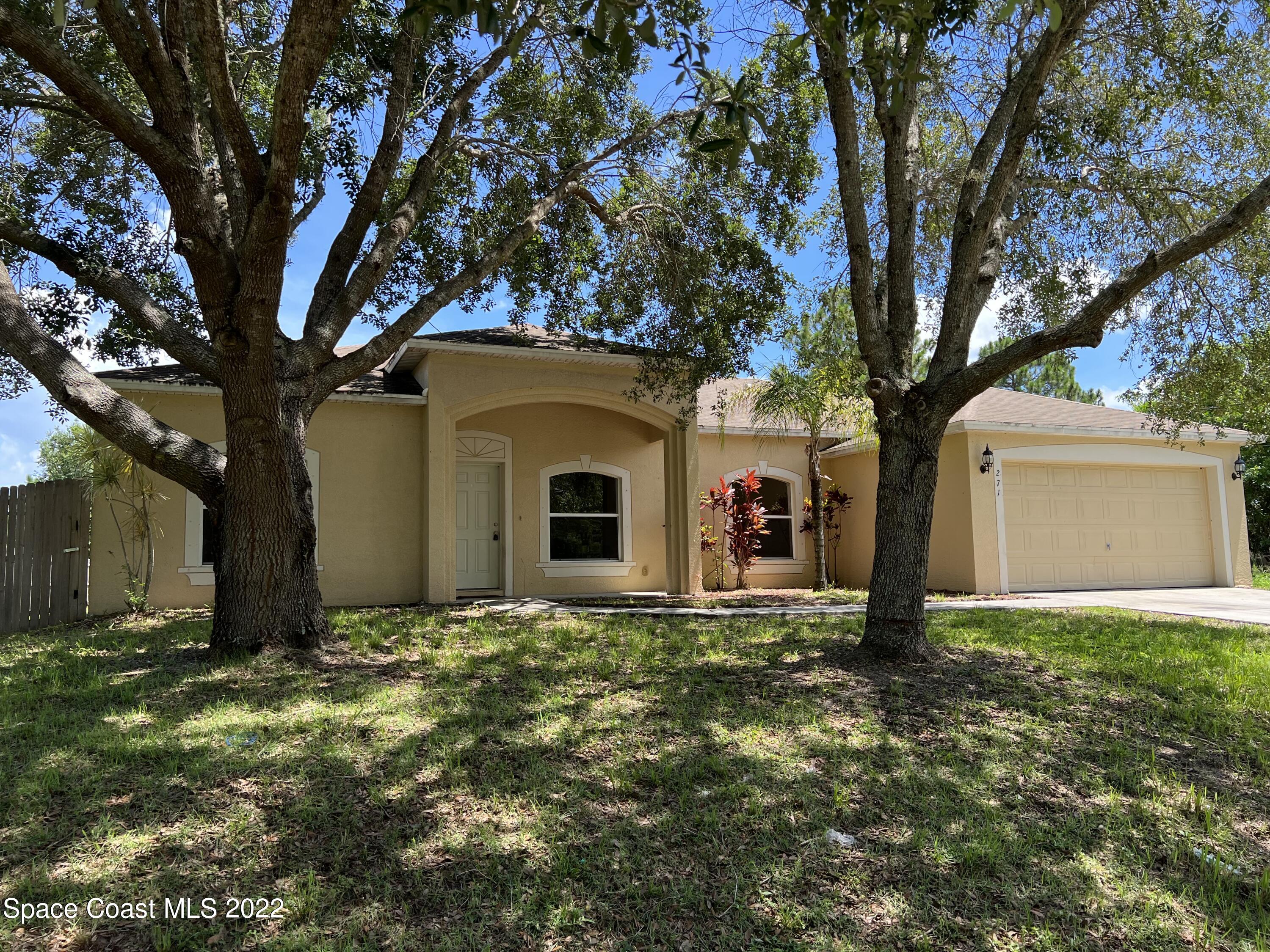 271 Titan Road Southeast Palm Bay, FL 32909 - Photo 1 of 22 a front view of house with yard and trees