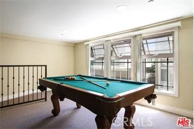 a room with pool table and windows