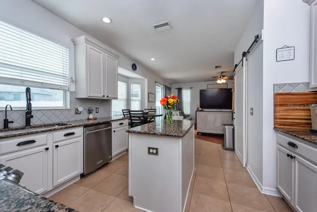 a kitchen with stainless steel appliances granite countertop a refrigerator and a stove top oven