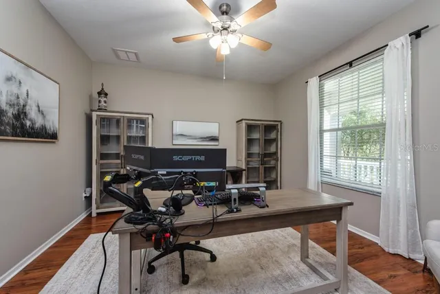 a view of a workspace with furniture and a window