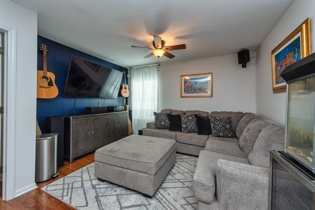 a living room with furniture and a ceiling fan