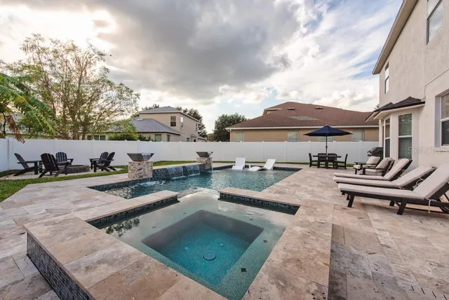 a view of a patio with furniture and a table and chairs under an umbrella