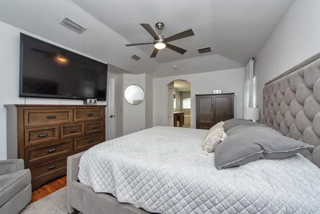 a bedroom with a bed and a flat screen tv