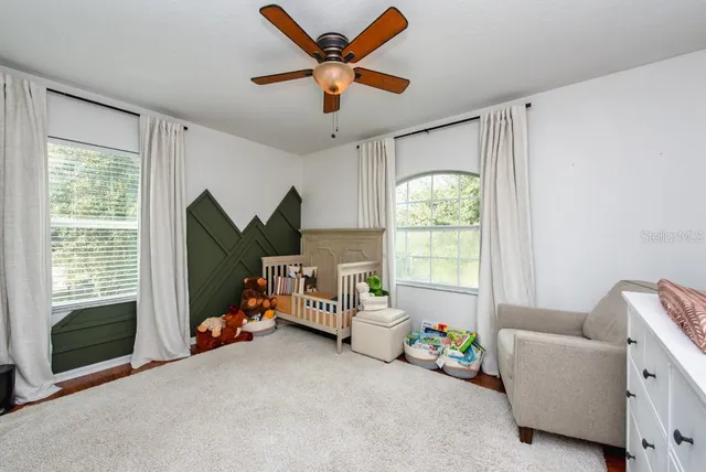 a bedroom with furniture and a large window