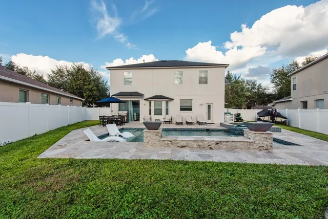 a view of a patio with table and chairs potted plants and palm tree