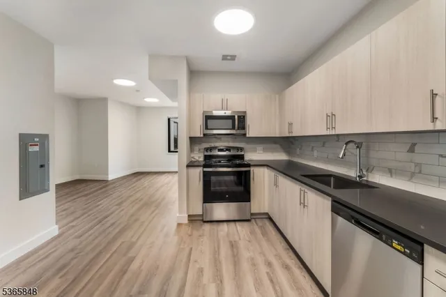 a kitchen with granite countertop a sink and cabinets