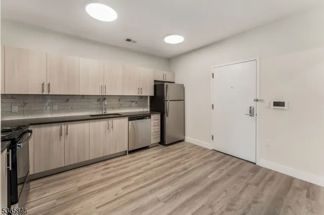 a kitchen with a sink a refrigerator and cabinets