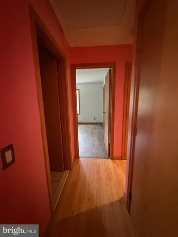 a room with wooden floor and paintings on the wall