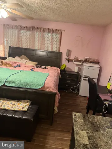 a bed sitting in a bedroom next to a window with wooden floor