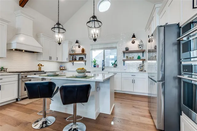 a kitchen with stainless steel appliances granite countertop a sink stove and refrigerator