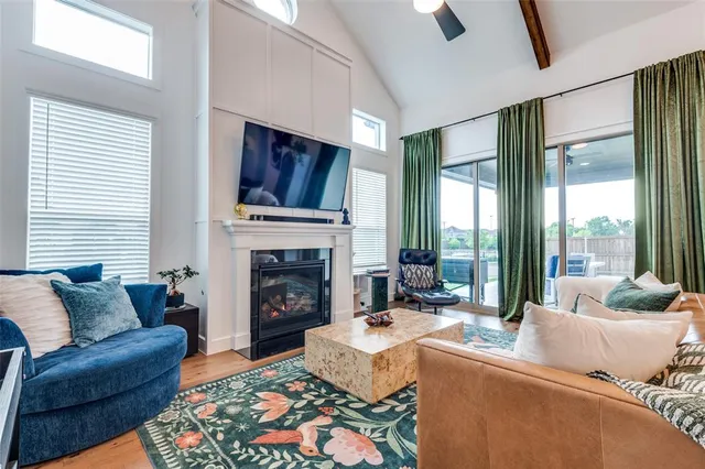 a living room with furniture fireplace and a large window