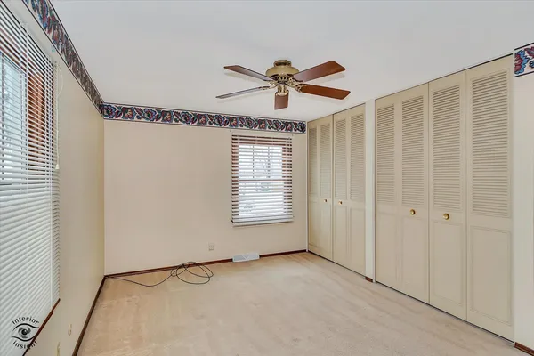 a view of a room with a window and a ceiling fan