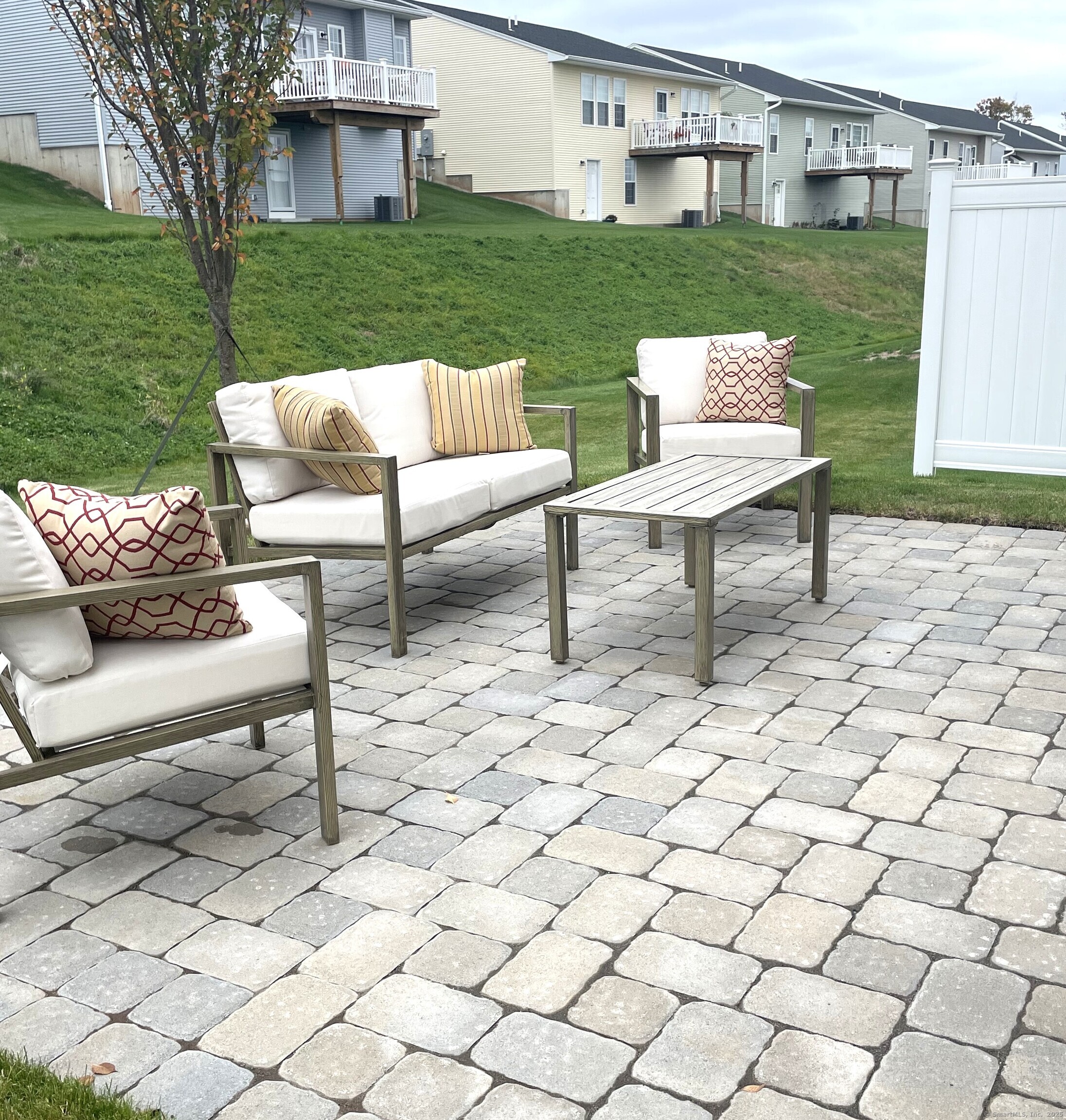 145 Webster Lane, Unit 241 Middletown, CT 06457 - Photo 18 of 22 a view of a yard and patio with a table and chairs