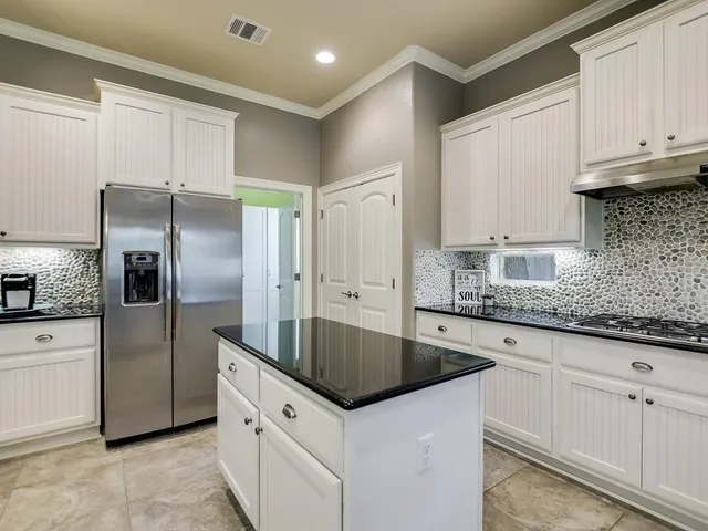 a kitchen with granite countertop a sink and refrigerator