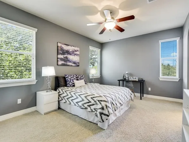 a bedroom with a bed chandelier and a window