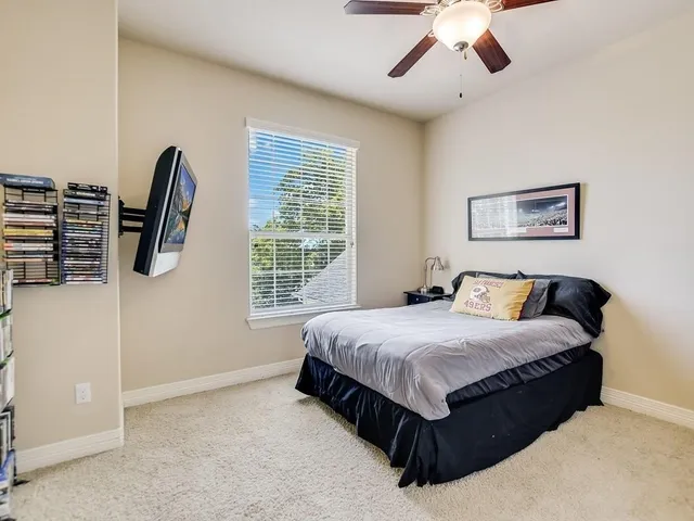 a spacious bedroom with a bed a window and dresser