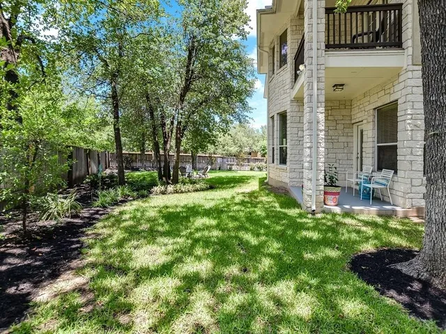 a view of a house with backyard and sitting area
