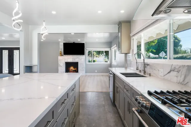 a large kitchen with stainless steel appliances granite countertop a stove and a sink
