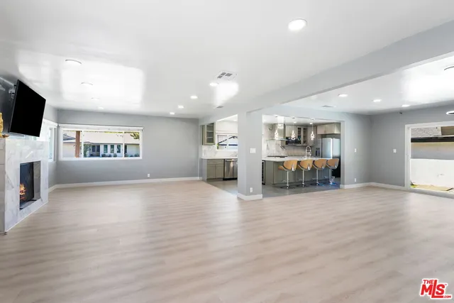 a view of a living room kitchen with furniture and flat screen tv