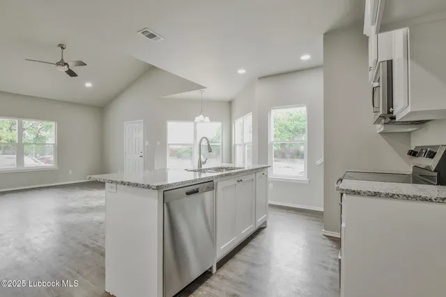 a kitchen with granite countertop a sink and cabinets