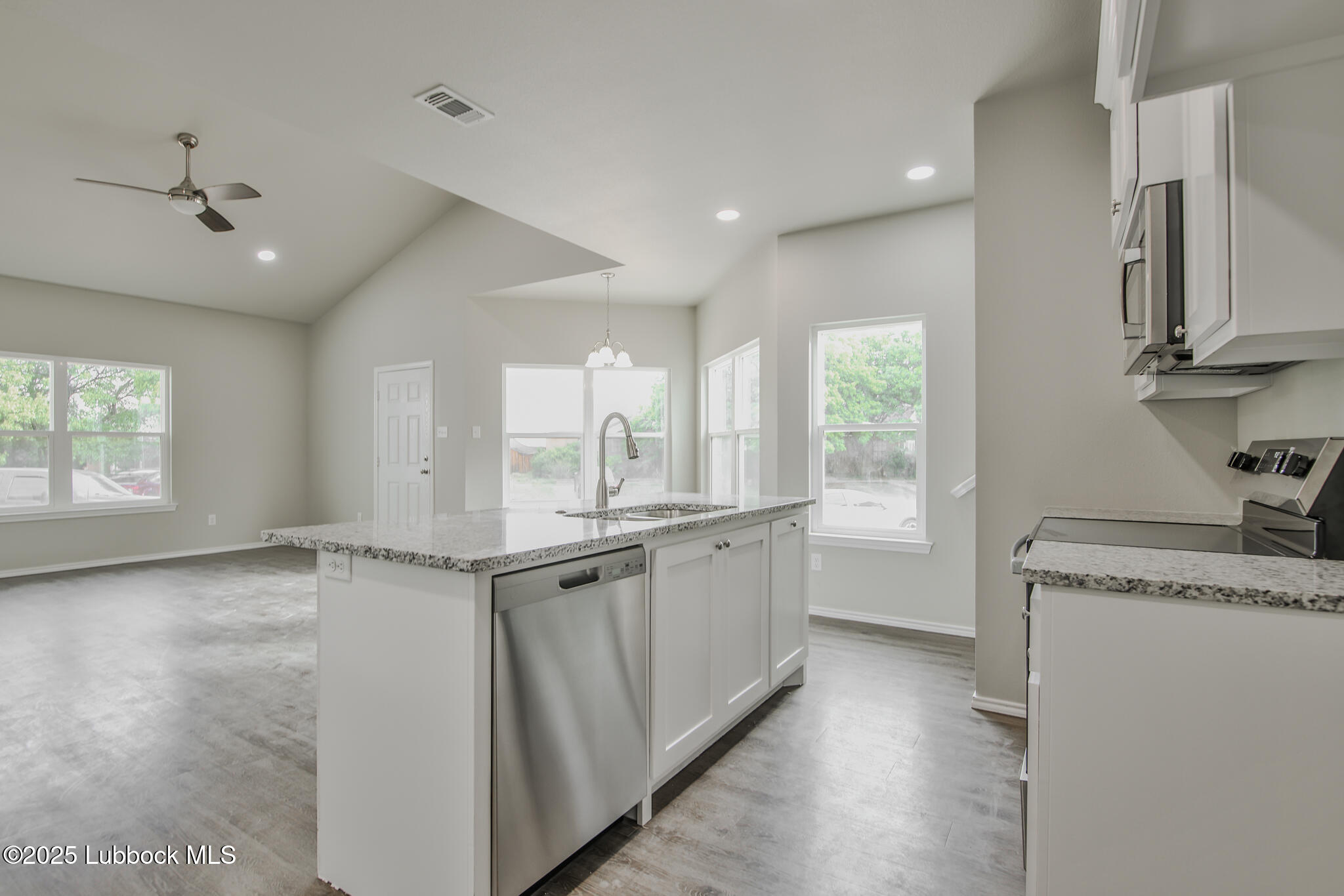 3115 74th Street Lubbock, TX 79423 - Photo 13 of 36 a kitchen with granite countertop a sink and cabinets