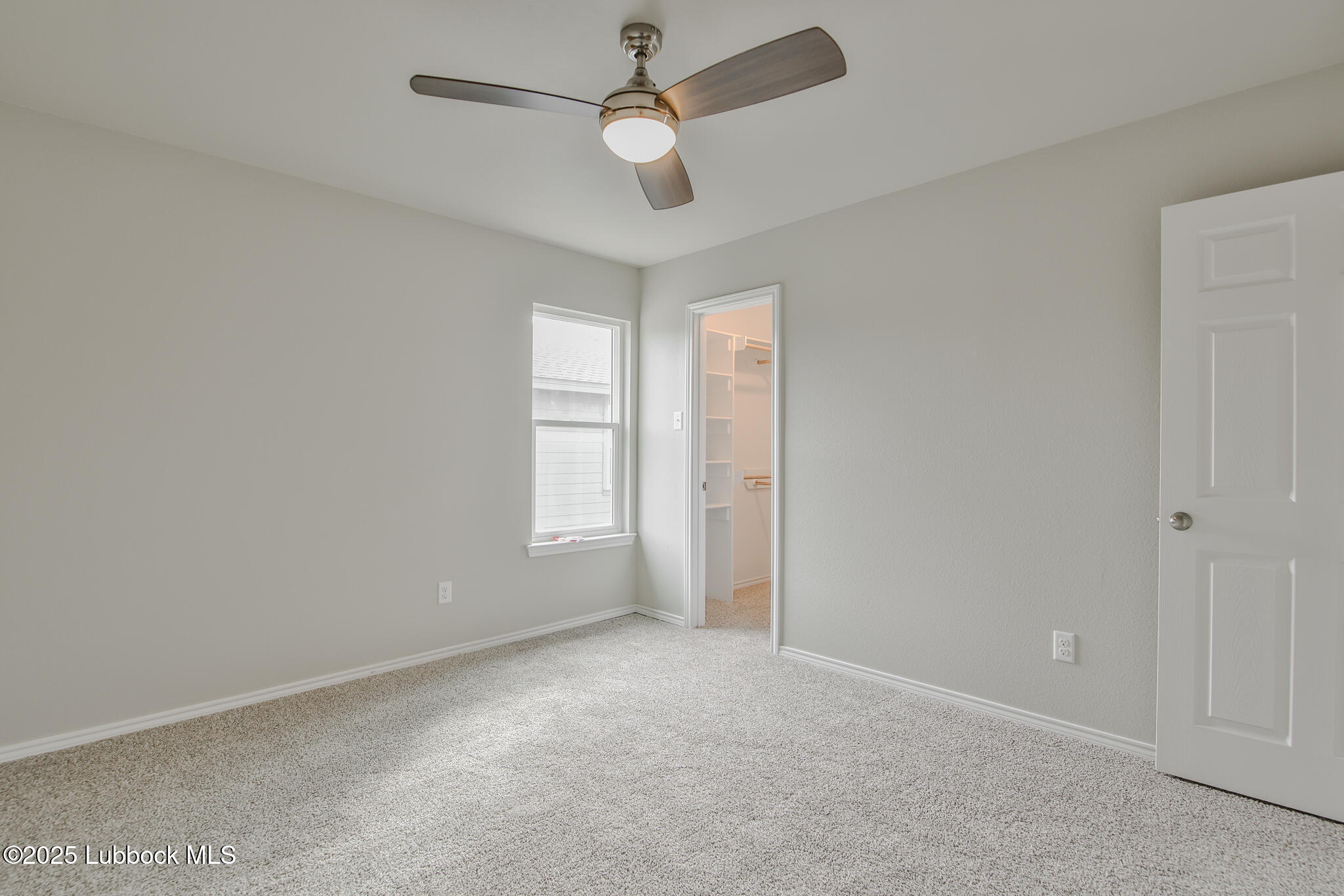 3115 74th Street Lubbock, TX 79423 - Photo 29 of 36 an empty room with a window and a fan