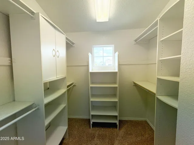 a view of walk in closet with empty racks