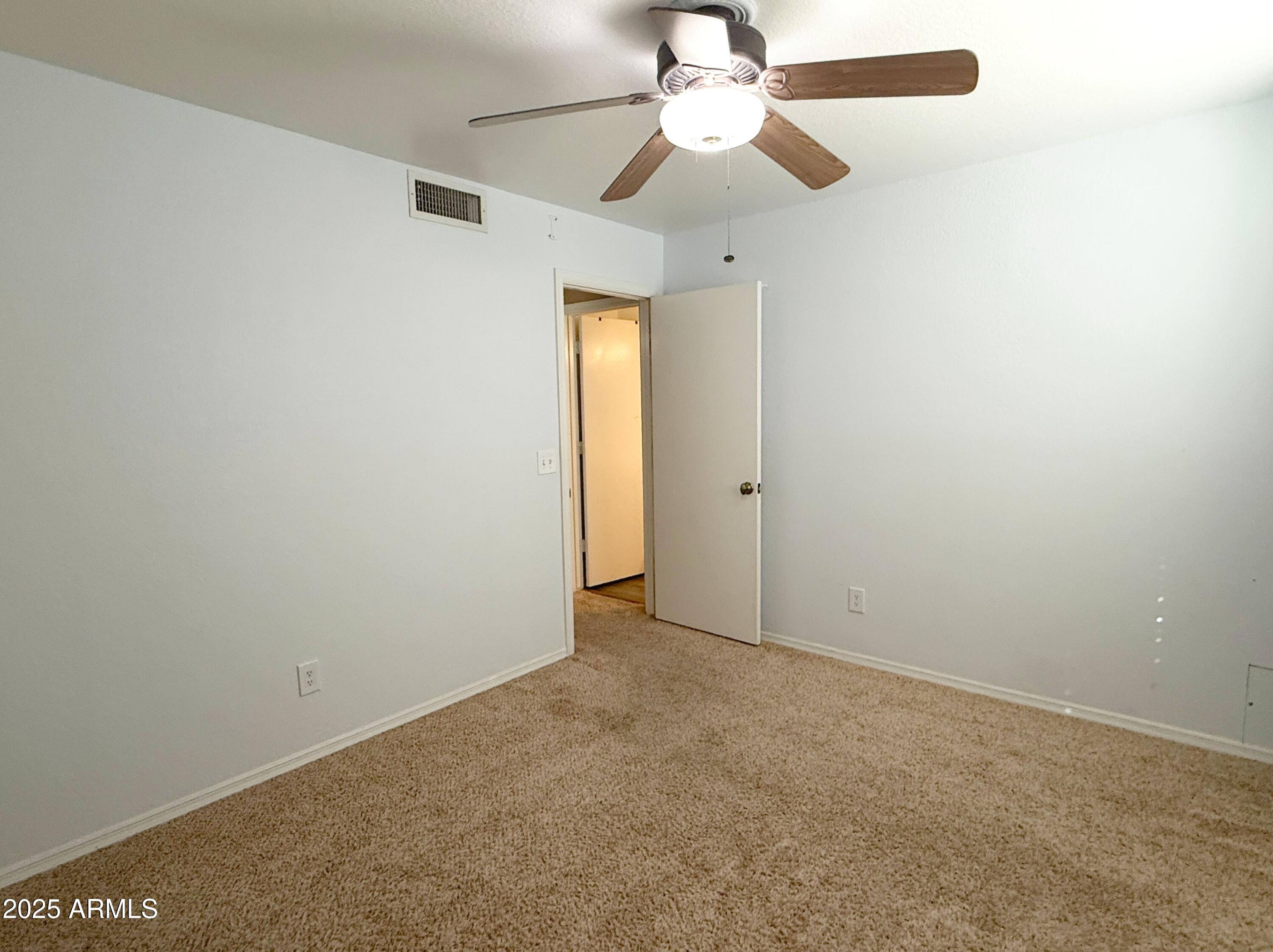 1670 East Gary Drive Chandler, AZ 85225 - Photo 27 of 34 an empty room with a chandelier fan and closet