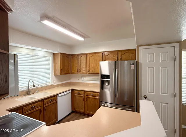 a kitchen with a refrigerator sink and cabinets