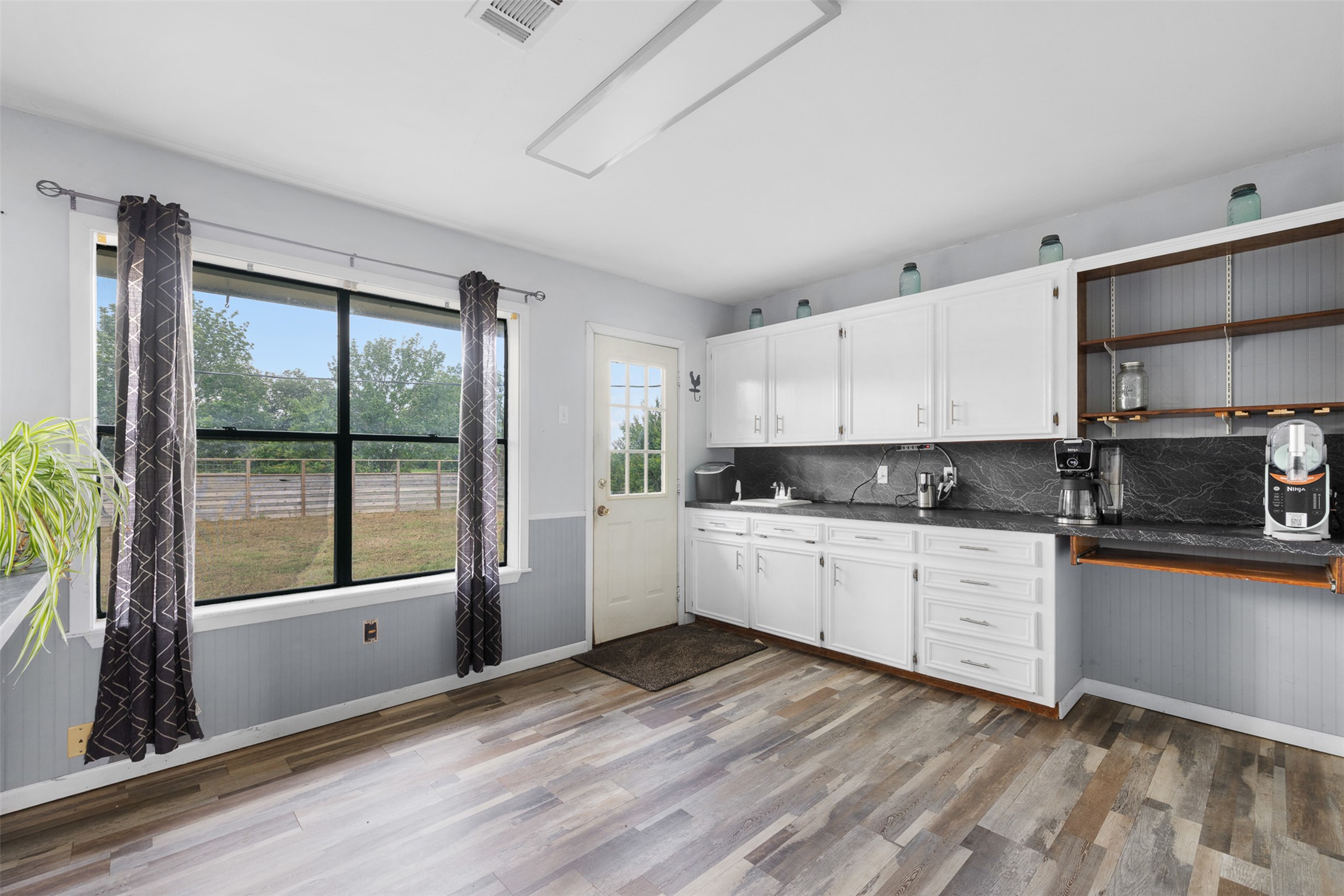 1015 FM 112 Road Lexington, TX 78947 - Photo 17 of 38 a kitchen with wooden floors and white appliances
